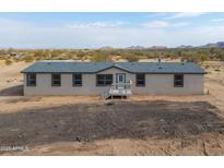 Single-story home with neutral exterior and deck at 645 S Warren Rd, Maricopa, AZ 85139