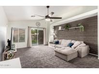 Living room with gray sectional sofa and wood accent wall at 15348 W Banff Ln, Surprise, AZ 85379