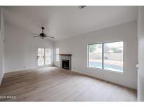Bright living room features a fireplace, wood-look floors, and sliding doors to a pool at 18429 N 16Th Way, Phoenix, AZ 85022