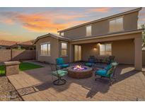 Inviting backyard featuring a paver patio with a cozy fire pit and comfortable seating for outdoor enjoyment at 2036 E Stacey Rd, Gilbert, AZ 85298