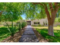 Inviting home featuring a lush front yard with desert landscaping and mature trees at 3601 N 55Th Pl, Phoenix, AZ 85018