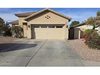 Tan home featuring a spacious two car garage and a large concrete driveway at 12558 W Jefferson St, Avondale, AZ 85323