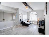 Living room with black leather sectional sofa and wood-look floors at 1905 E University Dr # 207, Tempe, AZ 85288