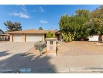 House exterior featuring a three-car garage and landscaped front yard at 4532 E Sandra Ter, Phoenix, AZ 85032