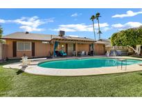 Beautiful backyard featuring a refreshing pool, well-maintained turf, and a covered patio area perfect for outdoor relaxation at 4762 E Pawnee Cir, Phoenix, AZ 85044