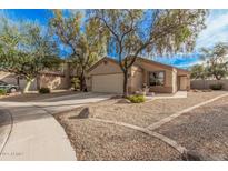 Single-story house with a two-car garage and desert landscaping at 11921 W Port Royale Ln, El Mirage, AZ 85335