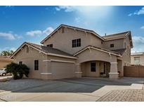 Two-story house with tan exterior, a three-car garage, and a landscaped front yard at 13305 W Indianola Ave, Litchfield Park, AZ 85340