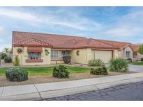 Single-story home with terracotta tile roof, landscaping, and a two-car garage at 14131 W Circle Ridge Dr, Sun City West, AZ 85375