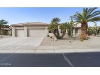 Single-story home with three-car garage and desert landscaping at 16036 W Sandia Park Dr, Surprise, AZ 85374