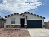 Charming single-story home featuring stone accents, a two-car garage, and desert landscaping at 17457 W Eva St, Waddell, AZ 85355
