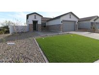 Charming single-story home featuring stone accents, a well-manicured lawn, and a two-car garage at 19315 W Luke Ave, Litchfield Park, AZ 85340