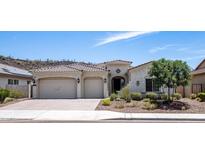 Single-story home with two-car garage,landscaped yard, and mountain views at 30401 N 115Th Dr, Peoria, AZ 85383