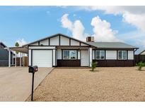 Cute ranch home with a white and brown exterior, nicely landscaped yard, and a two car garage at 3214 W Grovers Ave, Phoenix, AZ 85053