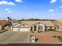 Beautiful single-story home with three-car garage and landscaped front yard at 4644 W Soft Wind Dr, Glendale, AZ 85310