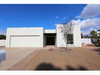 Single-story home with white exterior, two-car garage, and landscaping at 634 E Calavar Rd, Phoenix, AZ 85022