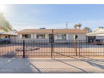 Ranch style home with a well-maintained front yard and a metal fence at 7501 E Pierce St, Scottsdale, AZ 85257