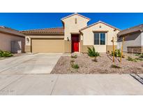 Single-story home with a red door and landscaped front yard at 16744 W Cavedale Dr, Surprise, AZ 85387