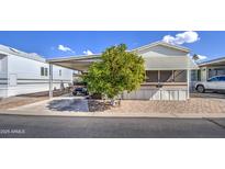 Single-wide manufactured home with carport, mature landscaping, and paved driveway at 7750 E Broadway Rd # 309, Mesa, AZ 85208