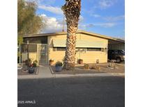 Tan single-wide manufactured home with mature palm tree in front at 11411 N 91St Ave # 80, Peoria, AZ 85345