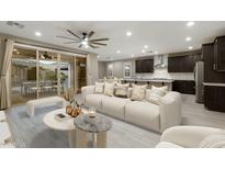 Bright living room featuring neutral tones, a large sofa, and seamless flow to the outdoor dining area at 12528 W Tuckey Ln, Glendale, AZ 85307