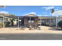 Tan mobile home with carport and landscaping at 2233 E Behrend Dr # 61, Phoenix, AZ 85024