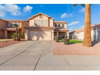 Two-story house with a tan exterior, two-car garage, and landscaped front yard at 4248 E Raven Rd, Phoenix, AZ 85044