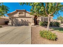 Tan house with two-car garage, landscaping, and driveway at 43726 W Carey Dr, Maricopa, AZ 85138