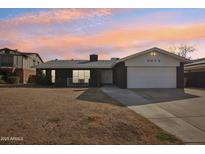 Updated single-story home with a two-car garage and well-maintained lawn at 5013 W Orchid Ln, Glendale, AZ 85302