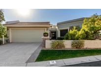 Tan stucco house with a two-car garage and well-manicured lawn at 8100 E Camelback Rd # 14, Scottsdale, AZ 85251