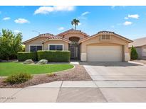 Charming single-story home featuring a well-manicured lawn and a two-car garage on a sunny day at 9713 E Onza Ave, Mesa, AZ 85212