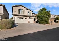 Two-story house with three-car garage and landscaped front yard at 9830 E Acacia Dr, Scottsdale, AZ 85260