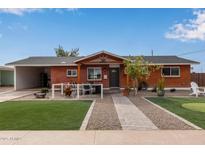 Brick ranch home with landscaped yard, putting green, and walkway at 1561 W 5Th St, Mesa, AZ 85201