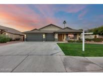 Charming single-story home with a three-car garage, lush lawn, and desert landscaping at 22852 N 103Rd Ave, Peoria, AZ 85383