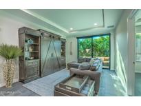 Living room with sectional sofa, large window, and built-in shelving at 6803 E Main St # 1110, Scottsdale, AZ 85251