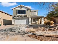 Two-story house with a white garage door and landscaping at 7223 S 41St Ln, Phoenix, AZ 85041