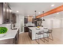 Modern kitchen with island, stainless steel appliances, and dark wood cabinets at 1413 N Sunview Pkwy, Gilbert, AZ 85234