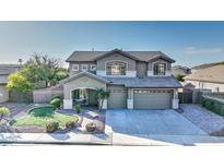 Two-story house with landscaped yard, two-car garage, and a welcoming front porch at 1811 E Powell Way, Chandler, AZ 85249