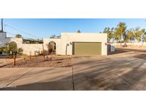 Front view of a single-story home with a green garage door and desert landscaping at 2916 S Price Rd, Tempe, AZ 85282