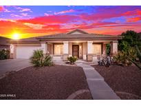 Inviting single-story home featuring manicured desert landscaping, a covered porch, and a two-car garage at 42276 W Chisholm Dr, Maricopa, AZ 85138