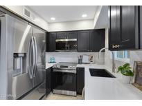 Modern kitchen features stainless steel appliances and white quartz countertops at 601 E Palo Verde Dr # 14A, Phoenix, AZ 85012