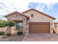 One-story home with stone accents and a brown garage door at 8725 E Indigo St, Mesa, AZ 85207