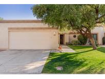 Tan stucco house with a two-car garage and nicely landscaped front yard at 9127 W Kimberly Way, Peoria, AZ 85382