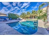 Inviting backyard oasis featuring a sparkling pool, lush landscaping, and patio seating at 9778 E Barley Rd, Florence, AZ 85132