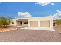 Beige home with two-car garage and desert landscaping at 1628 E Magellan Dr, New River, AZ 85087