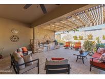 Covered patio with built-in grill, seating area, and stone accents at 18114 W Desert Sage Dr, Goodyear, AZ 85338