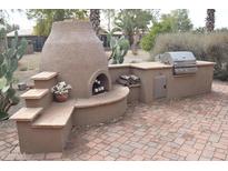 Outdoor kitchen with built-in grill, pizza oven, and stone countertops at 2425 E Durango Dr, Casa Grande, AZ 85194