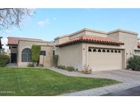 Tan stucco home with tile roof, 2-car garage, and landscaped lawn at 4116 E Sunnyside Dr, Phoenix, AZ 85028