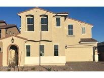 Two-story home featuring a desert landscape, brick driveway, and an attached two-car garage at 5857 S Romano --, Mesa, AZ 85212