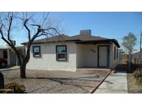 Cute bungalow features a well-maintained exterior, freshly painted, and a small front yard at 676 N 7Th Pl, Coolidge, AZ 85128