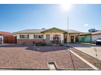 Brick ranch house with carport and landscaped front yard at 6815 W Reade Ave, Glendale, AZ 85303